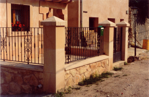 Pilares y albardillas de Piedra Rosa Sepúlveda abujardada y muros de mampostería en vivienda unifamiliar de Sepúlveda (Segovia).